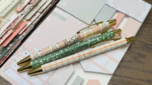 Load image into Gallery viewer, Set of pens with decorative designs and text on a patterned surface